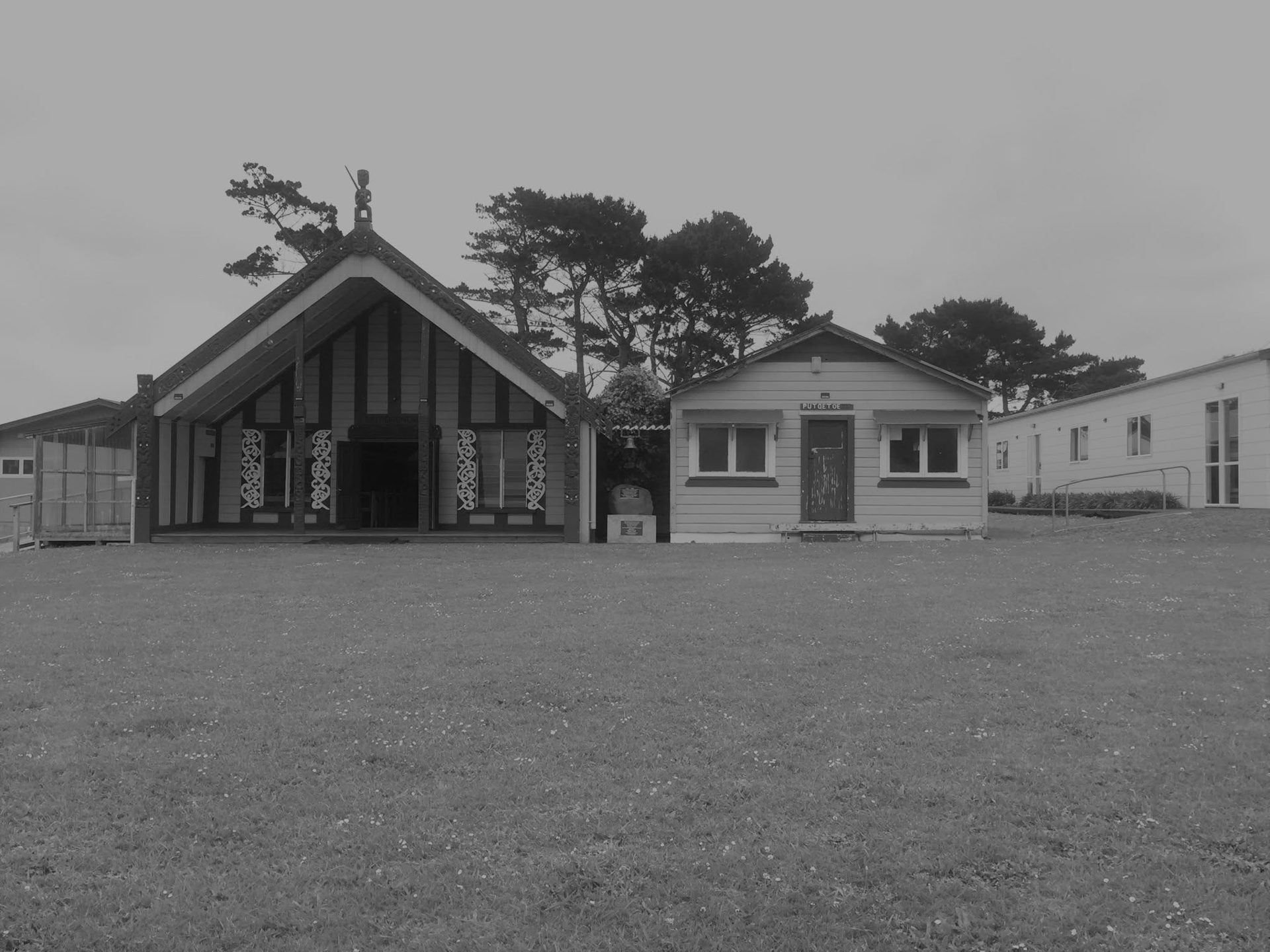 The wharenui and dining rooms of Pariroa Pā in an early black and white photograph